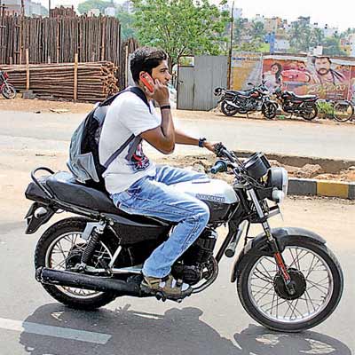 Traffic violation in Odisha. Phone on bike